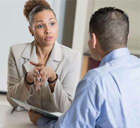 Two people in conversation across a table while reviewing care arrangements.